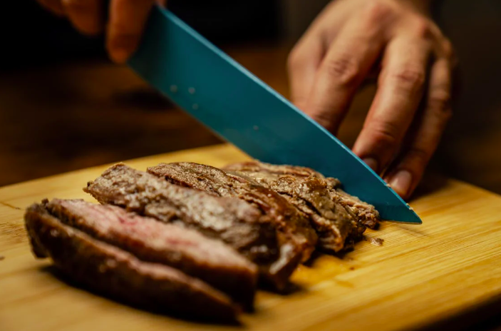 Steak finely sliced into pieces for serving using a sharp knife.